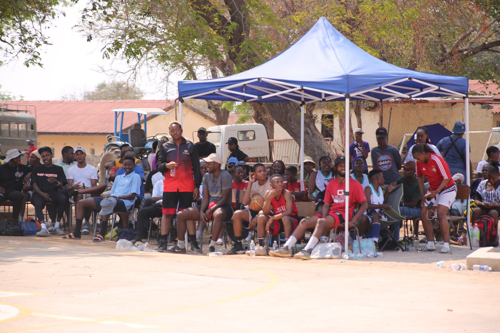 Supporters watch from under a tent