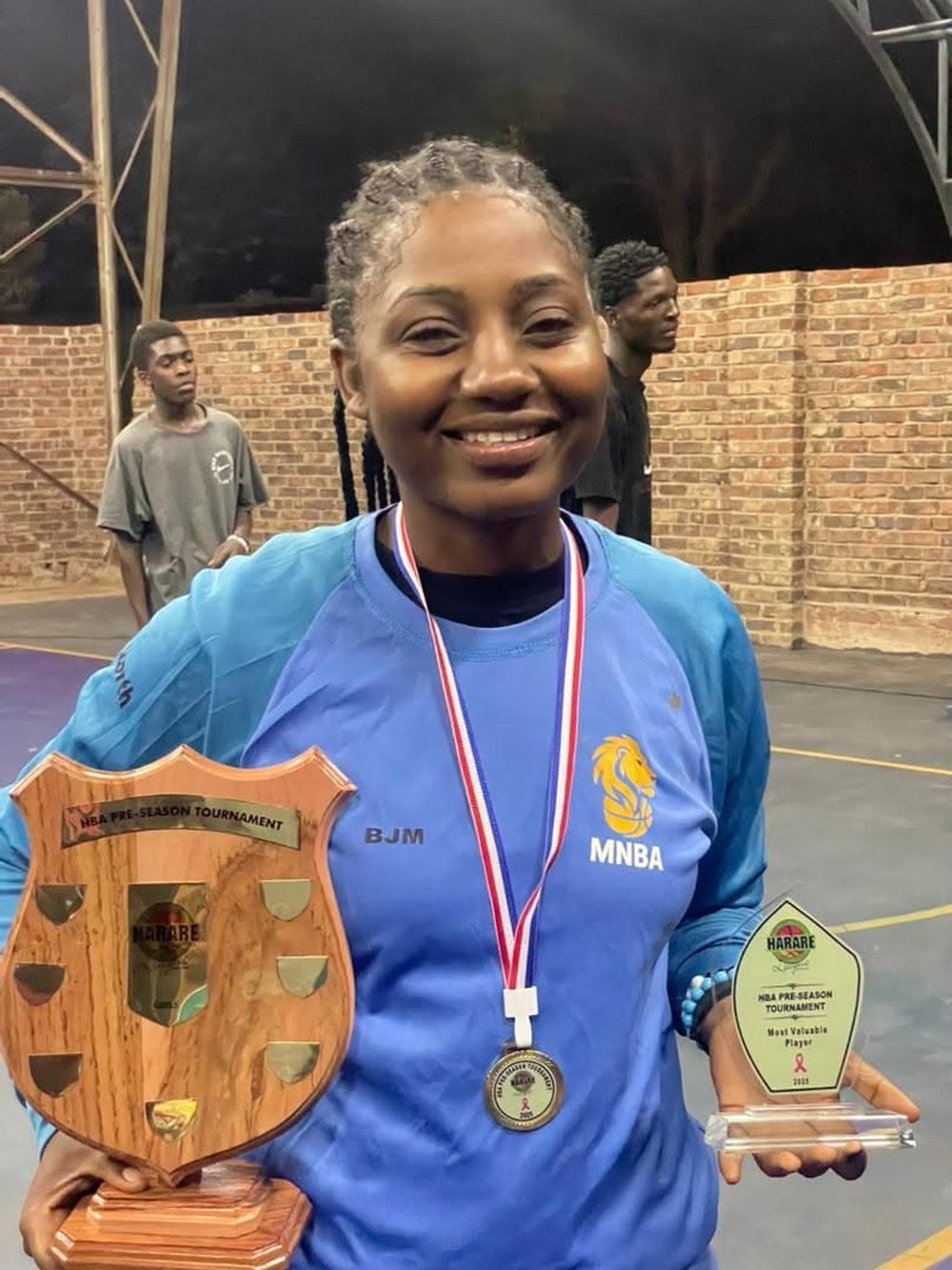 A woman player with her Most Valuable Player award and tournament shield