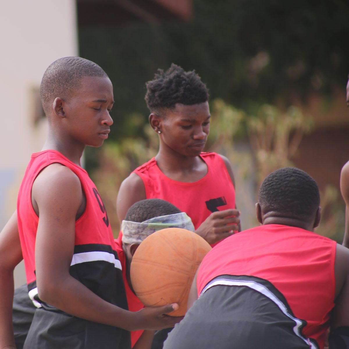 Young players in a team huddle holding the ball